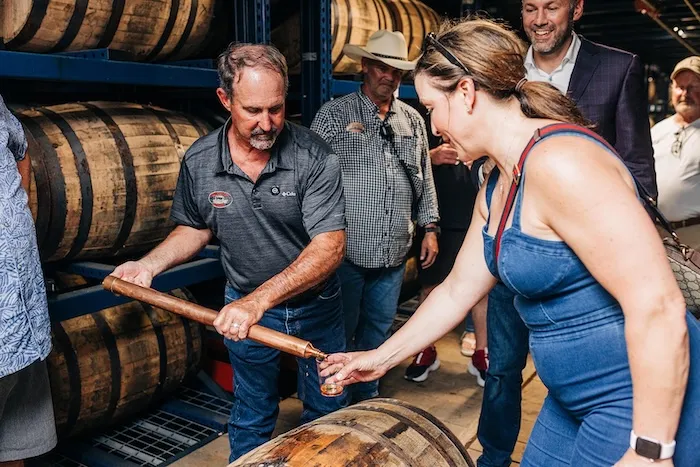 Bourbon barrel aging in a rickhouse with warm amber tones.
